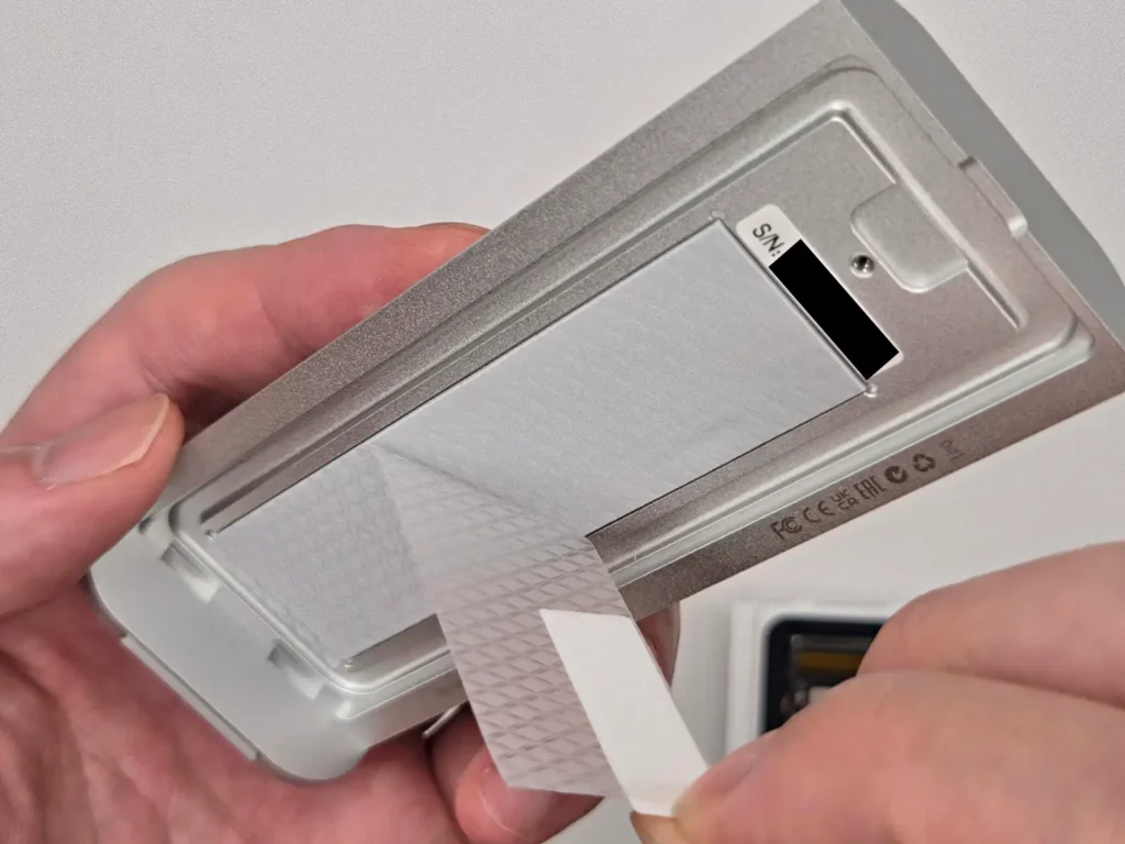 TerraMaster D1 SSDの熱伝導パッド保護フィルムを剥がしている様子