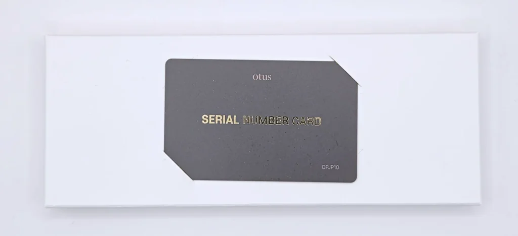 OTUS付属のシリアルナンバーカード、ダークグレーに金字でSERIAL NUMBER CARDのロゴとOPJP10の型番