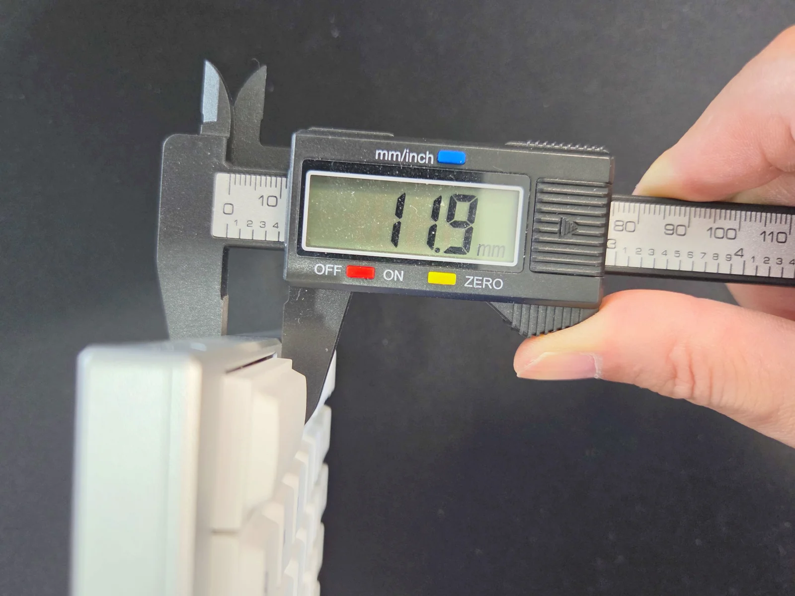 Elimkeys Elytraのアルミ筐体の最薄部をノギスで計測、11.9mmを表示