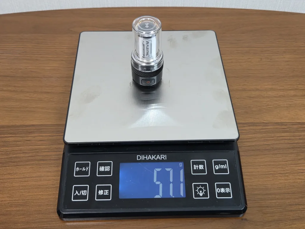 キッチンスケールに立てて載せたFLEXTAIL ZERO LANTERN。表示は57.1g