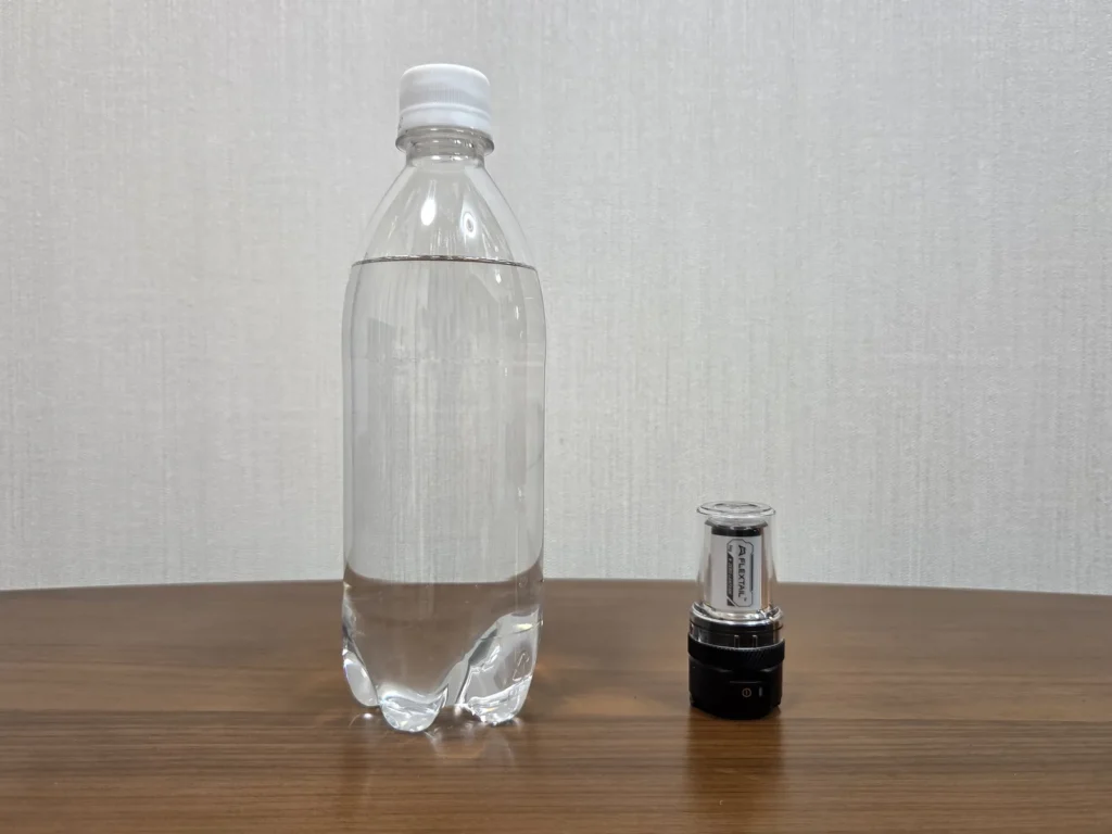 500mlのペットボトルと並べて立てた本体。高さはボトルの半分に届かない