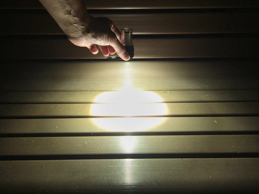 LEDライトモード最大の200lmでベンチの座面を照らすと、輪郭のはっきりした白い楕円ができる