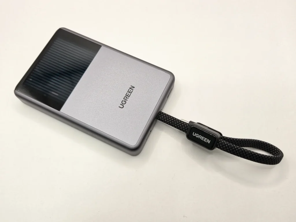 UGREEN MagFlow Pro を斜めから見た外観、上半分に水冷窓、下にストラップを兼ねた内蔵ケーブル