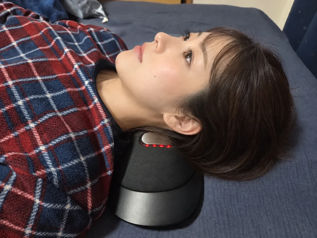NIPLUX NOBI FITを首の下に敷いて仰向けに寝ている様子、中央のパッドが赤く光っている