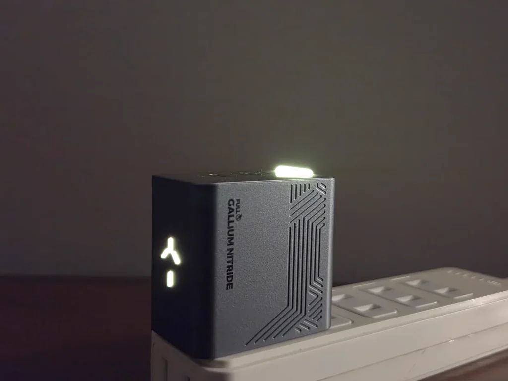 暗くした寝室で光る PHYSCE 35W 充電器、淡い黄緑のライト