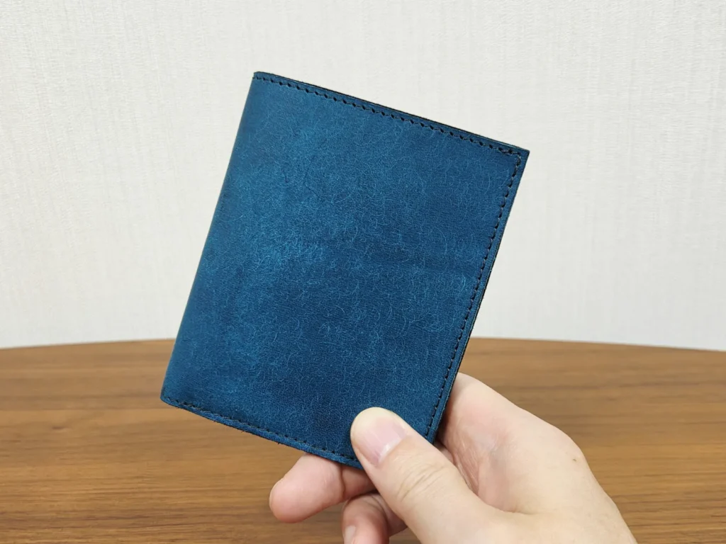 SOLAHANPU Tenuis フラップタイプ碧緑を手に持った正面、和紙のようなマットな青緑の革
